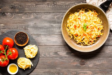 Tagliatelle mantarlı domates ve fesleğen, evde, ahşap bir bac üzerinde yapılan