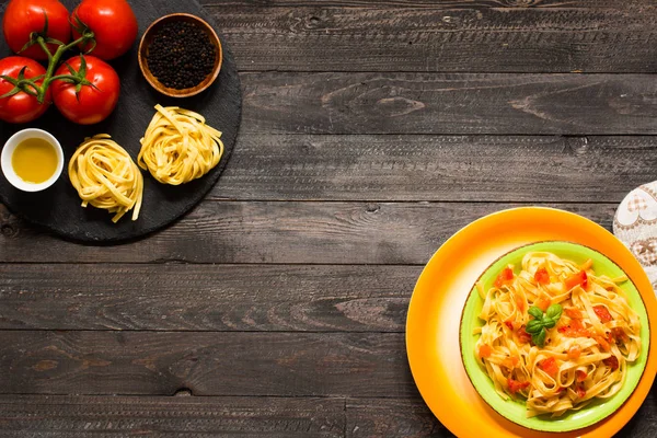 Tagliatelle mit Tomate und Basilikum, zu Hause zubereitet, auf einem hölzernen Bac — Stockfoto