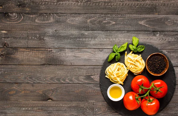 Tagliatelle with tomato and basil, made at home, on a wooden bac — Stock Photo, Image