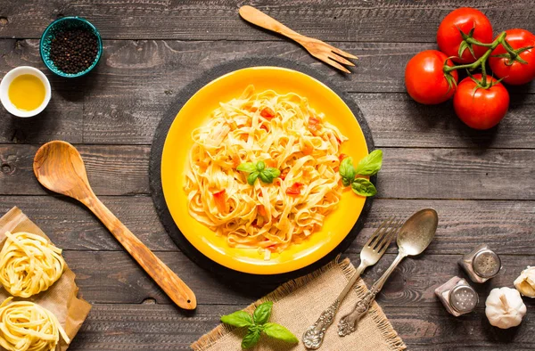 Tagliatelle com tomate e manjericão, feito em casa, sobre um bac de madeira — Fotografia de Stock