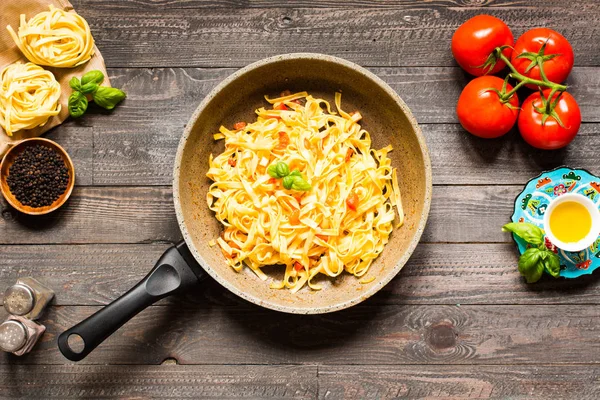 Tagliatelle com tomate e manjericão, feito em casa, sobre um bac de madeira — Fotografia de Stock