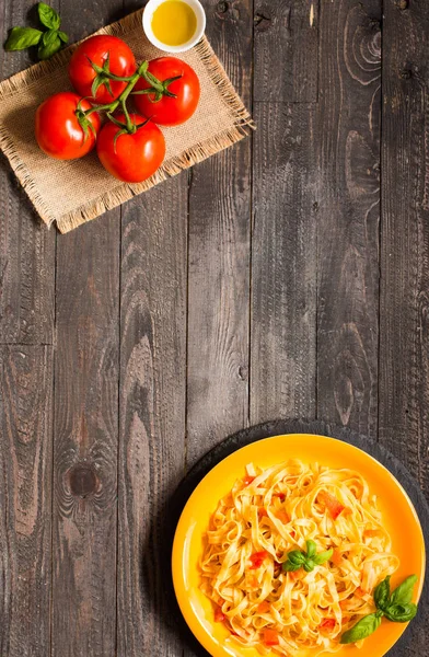 Tagliatelle mit Tomate und Basilikum, zu Hause zubereitet, auf einem hölzernen Bac — Stockfoto