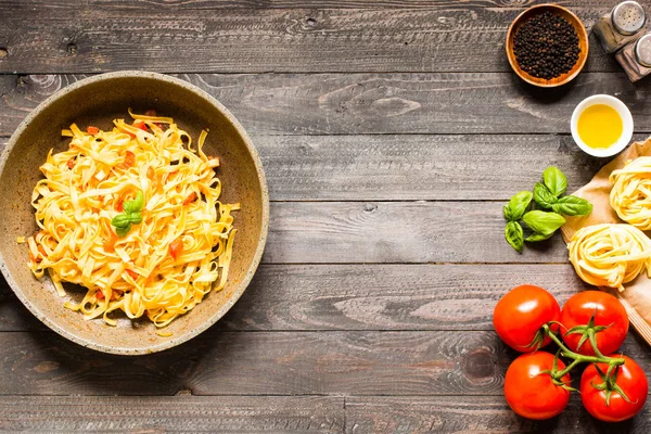 Tagliatelle com tomate e manjericão, feito em casa, sobre um bac de madeira — Fotografia de Stock