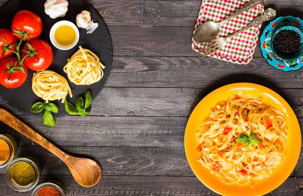 Tagliatelle com tomate e manjericão, feito em casa, sobre um bac de madeira — Fotografia de Stock