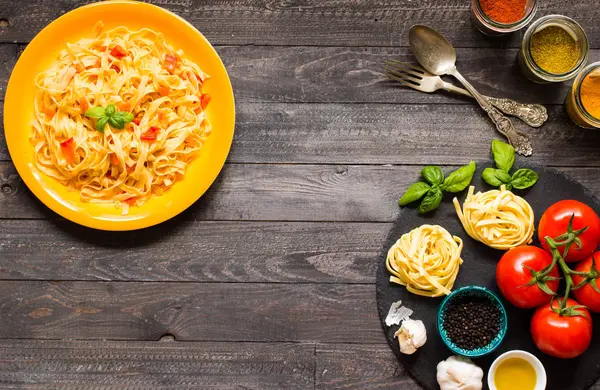 Tagliatelle com tomate e manjericão, feito em casa, sobre um bac de madeira — Fotografia de Stock