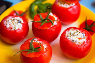 Bir woo üzerinde farklı sebze ve peynir ile doldurulmuş domates