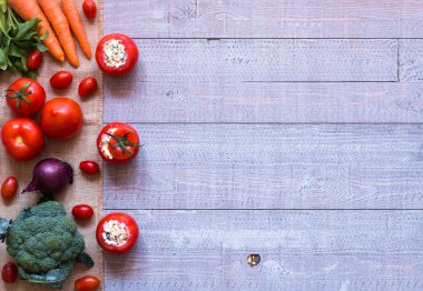 Bir woo üzerinde farklı sebze ve peynir ile doldurulmuş domates