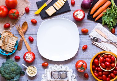 Bir woo üzerinde farklı sebze ve peynir ile doldurulmuş domates