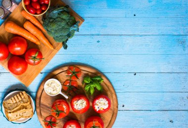 Bir woo üzerinde farklı sebze ve peynir ile doldurulmuş domates