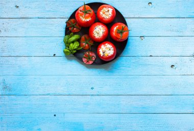 Bir woo üzerinde farklı sebze ve peynir ile doldurulmuş domates