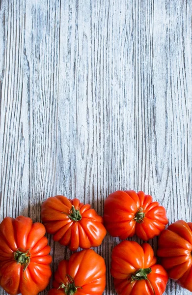 Ox heart tomatoes, on rustic wood background, free space for tex