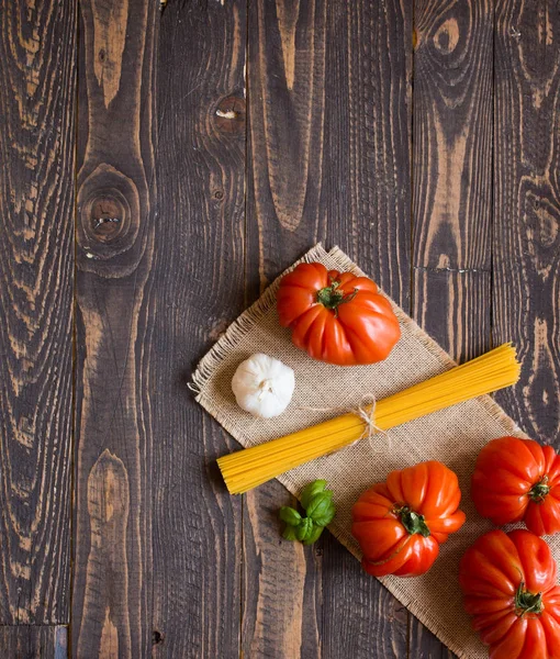 Ox heart tomatoes, on rustic wood background, free space for tex