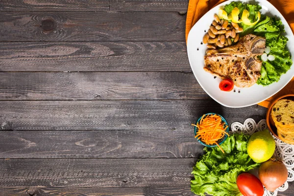 Domuz eti biftek baharatlarla yemek ev yapımı ahşap üzerinde marul yaprakları