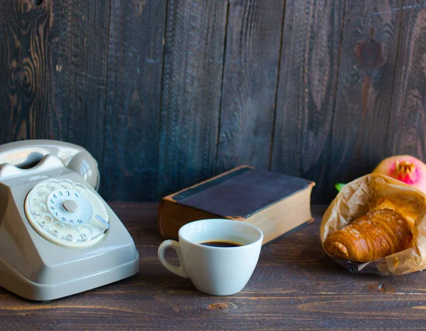 Old vintage telephone, coffee, book, on a wooden background, — Stock Photo, Image