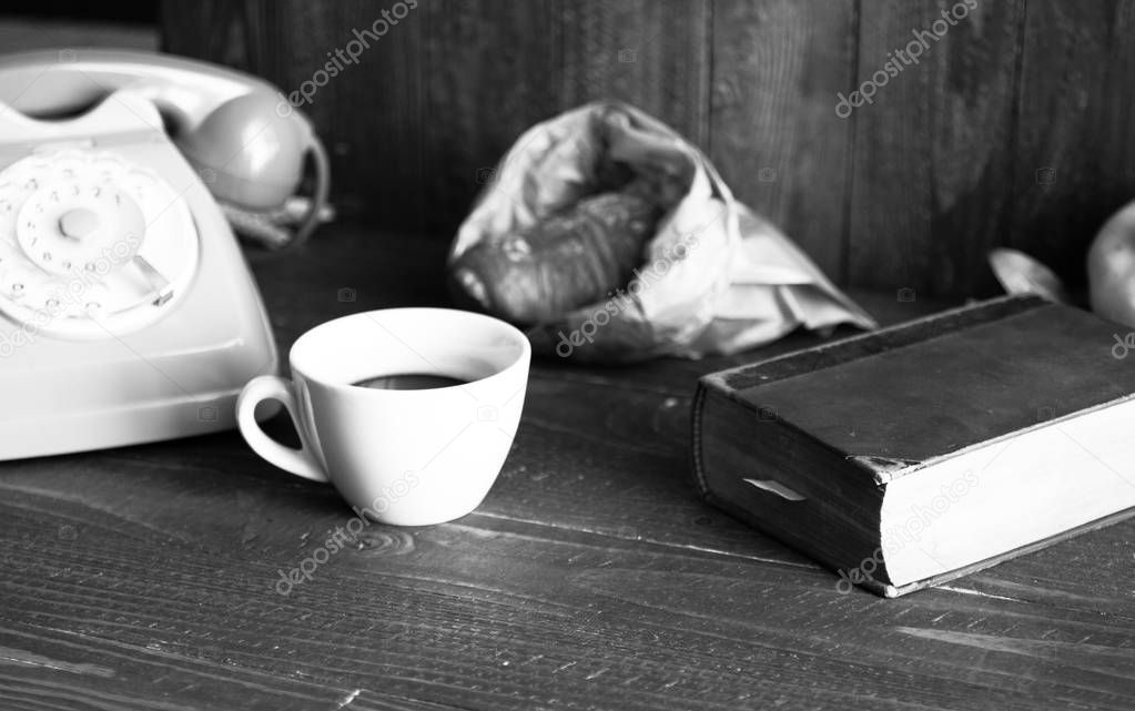 Old vintage telephone, coffee, book, on a wooden background, 