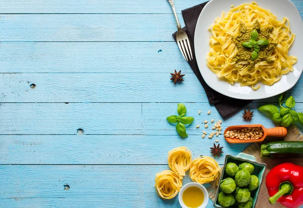 Pasta tagliatelle con salsa de pesto y otras verduras en un woo —  Fotos de Stock