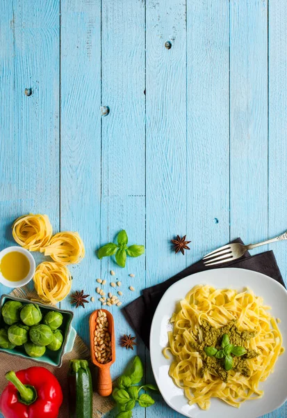 Pasta tagliatelle con salsa de pesto y otras verduras en un woo —  Fotos de Stock