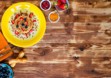 Taze çilek, çilek, yaban mersini ve ahşap arka plan üzerinde akçaağaç şurubu ile ev yapımı gözleme. Metin için boş alan