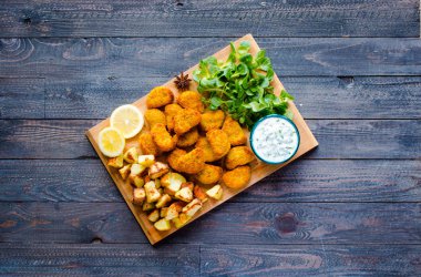 Ahşap bir zemin üzerine yoğurt soslu tavuk nuggets 