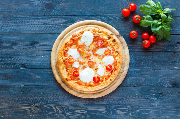 Top view of italian classic pizza margherita over a wooden table