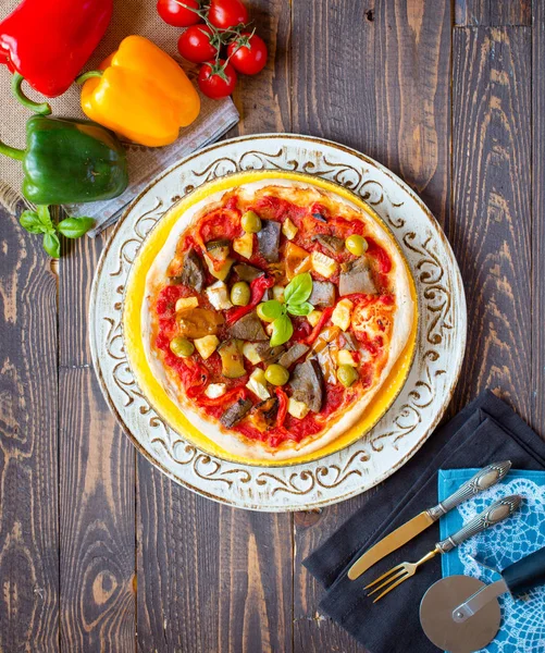 Fresh homemade pizza with different vegetables on a wooden backg — Stock Photo, Image