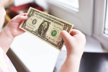 bir çocuğun elinde dolarlık banknot