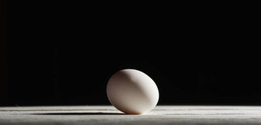 siyah bir arka plan beyaz bir masada çiğ beyaz yumurta tavuk