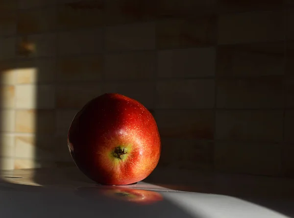 A red Apple on a white table on a black background — Stock Photo, Image