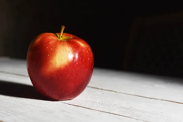 A red Apple on a white table on a black background — Stock Photo, Image