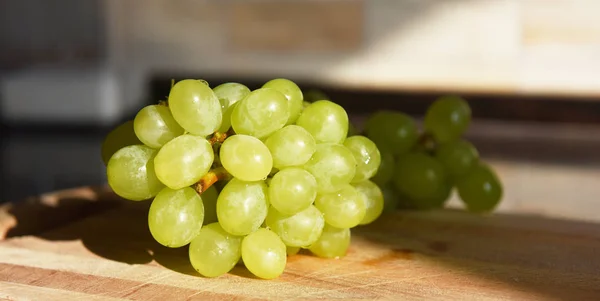 Um monte de uvas em tábua de madeira — Fotografia de Stock