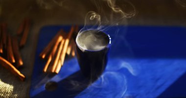 Mavi duman tarçın ile mavi arka plan ile kahve fincan