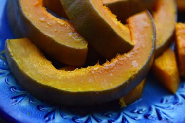 Ahşap bir masada dilimlenmiş portakal kabağı.