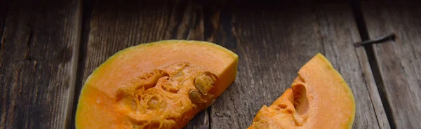 ripe orange pumpkin sliced on a wooden table