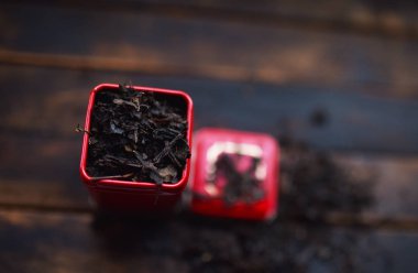 Siyah çay kırmızı bir teneke kutuda koyu bir arka planda