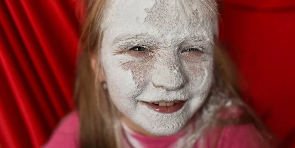 child\'s face in powdered sugar close up