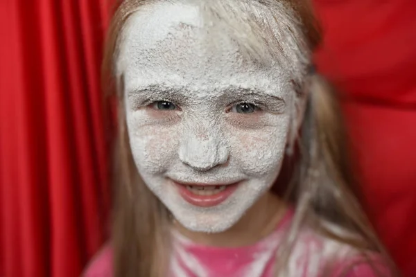 child\'s face in powdered sugar close up