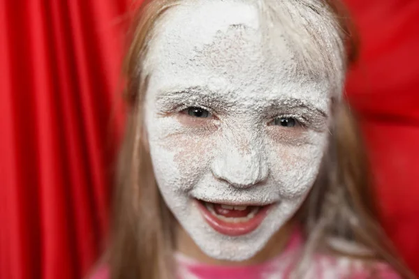 child's face in powdered sugar close up
