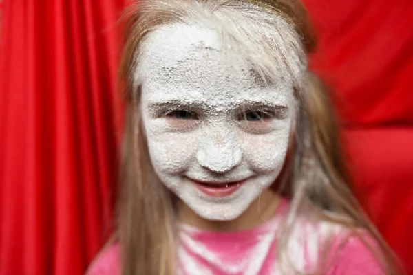 child\'s face in powdered sugar close up