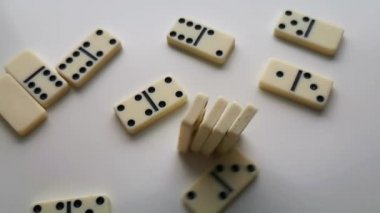 Dominolar beyaz, siyah noktalar düşüyor ve zıplıyor.