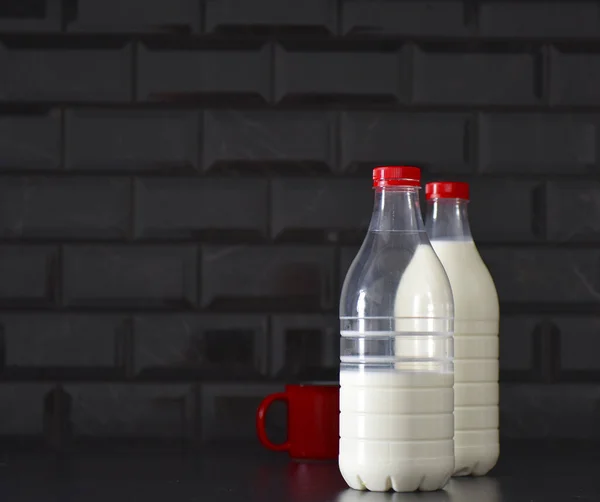Πλαστικά Μπουκάλια Γάλακτος Και Μια Κόκκινη Κούπα — Φωτογραφία Αρχείου