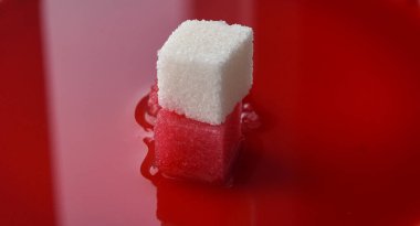 Bir parça şeker kırmızı şurupla ıslanır.