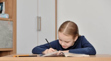 Masada ders çalışan bir çocuk.