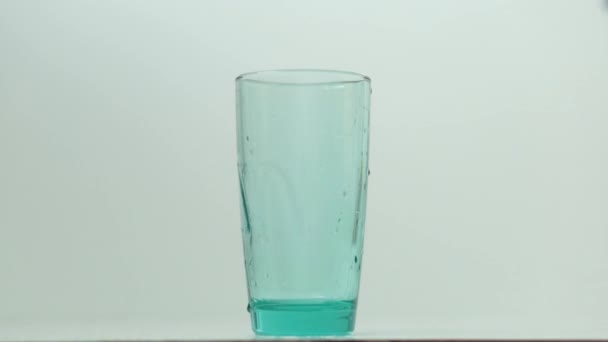 l'eau transparente claire se déverse d'en haut dans le verre 