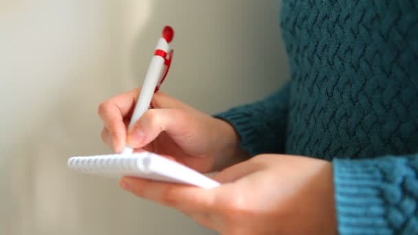 Mujer joven escribiendo en un cuaderno — Vídeo de stock