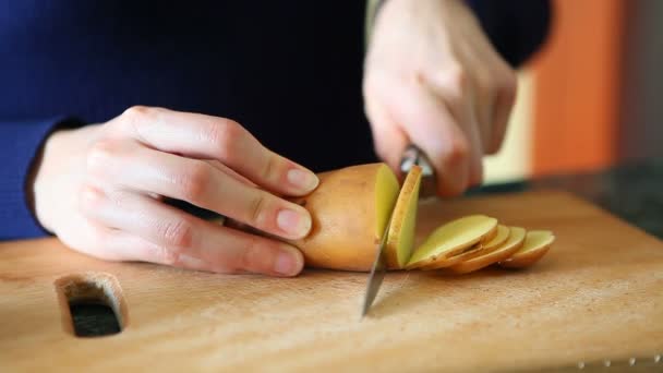 Cortar papas sobre tabla de madera — Vídeo de stock