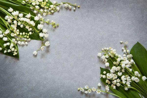 Gray background with flowers lily of the valley and copy space