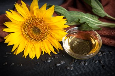 Sarı ayçiçeği ve tohumlar siyah arka plan üzerinde yağla