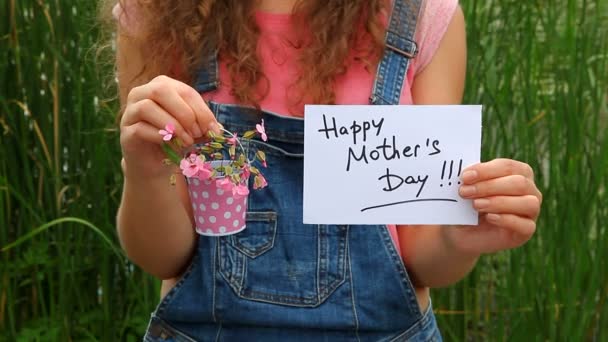 Happy mothers day, girl with card and pink flowers — Stock Video