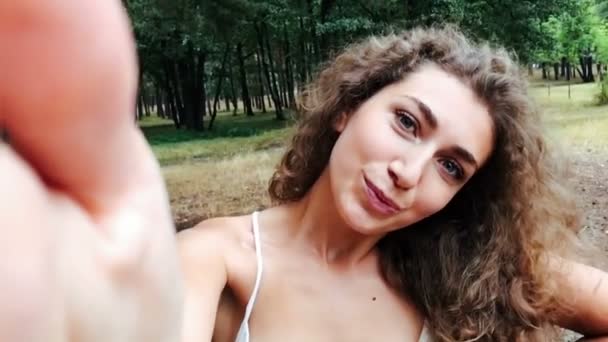 Mujer joven con el pelo rizado posando para selfie — Vídeo de stock