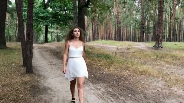 Vacker kvinna promenader i parken — Stockvideo